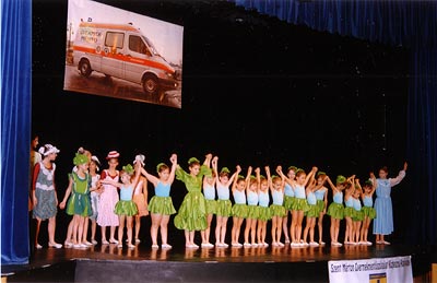 Gyerekek a színpadon, háttérben a Gyermekrohamkocsi fotója