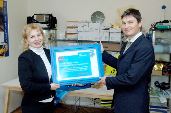 Szilvási Istvánné, a K&H Bank fiókvezetője átadja az adományukat Dr. Krivácsy Péternek