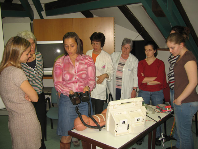 Dr. Szűcs Andrea a defibrillátor működését mutatja be a tanfolyam résztvevőinek.