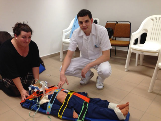 Két gyermekmentős kolléga gyakorol egy gyermekbábun