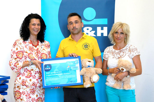 Horváth Magyary Nóra, Dr. Goschler Ádám, a Szent Márton Gyermekmentő Szolgálat képviselője és Barabás Éva a támogatást jelképező táblával és macival