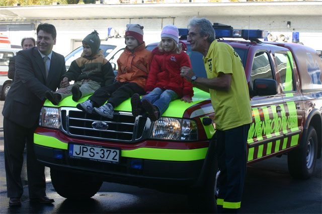 Gyerekek ülnek a gyermekmentő motorháztetőjén